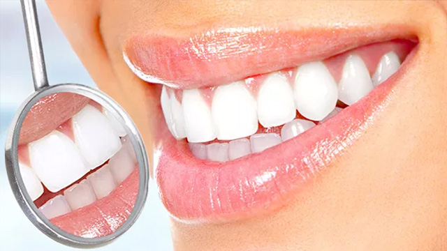 A woman s smiling face with teeth showing, alongside a magnifying mirror.