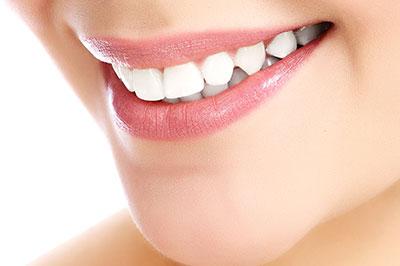 The image shows a close-up of a person s face with a focus on their teeth and lips, highlighting dental care or cosmetic dentistry services.